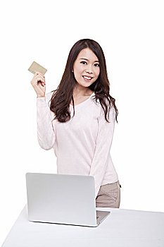 东方青年女子在电脑前拿着信用卡
