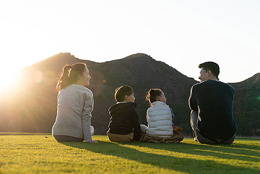 年轻家庭坐在草地上