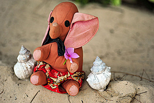 madagascar,tulear,ifaty,pink,elephant,sitting,in,the,sand,with,seashells