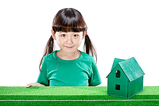 旁边放着小房子穿绿衣服的小女孩