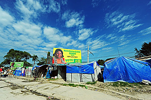 haiti,port,au,prince,presidential,campaign,advertisement,in,front,of,refugee,camp