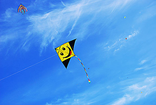 天空中飞翔着的黄色笑脸风筝