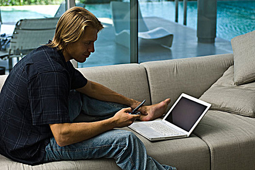 男人,坐,沙发,笔记本电脑,手机