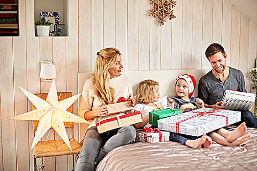 家庭,两个,成年人,两个孩子,坐,床上,圣诞节,开着,礼物,一起