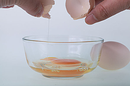 一只手给玻璃碗里打鸡蛋