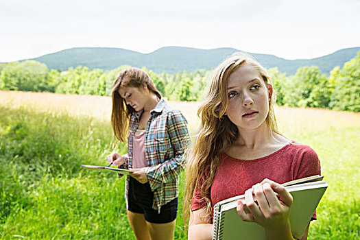 两个女孩,坐,户外,草地,速描板,铅笔