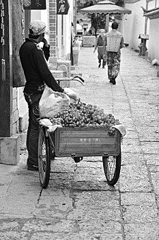 丽江古城街头贩卖葡萄的小贩