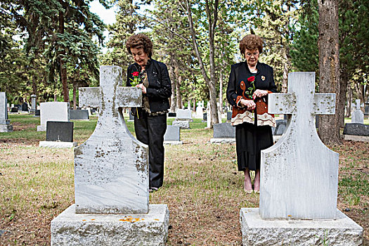 两个女人,拿着,一个,红玫瑰,站立,两个,墓穴,并排,墓地,埃德蒙顿,艾伯塔省,加拿大