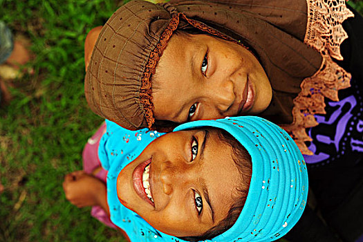 indonesia,sumatra,banda,aceh,two,smiling,girl,looking,up,with,colorful,veil