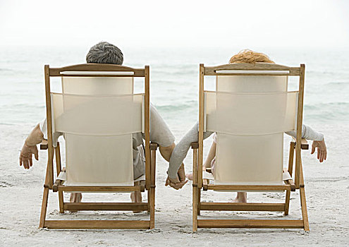 坐,夫妇,沙滩椅,握手,后视图