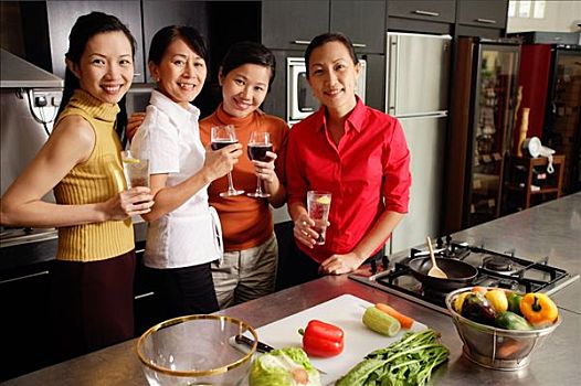 四个女人,厨房,拿着,葡萄酒杯,看镜头,微笑