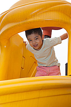小男孩在幼儿园内玩滑梯