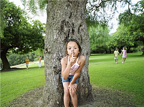 女孩,7-9岁,手贴唇,玩,捉迷藏,公园,隐藏,朋友,后面,树