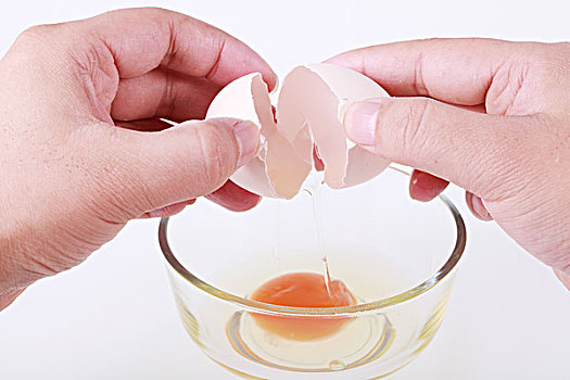 两只手给玻璃碗里打鸡蛋