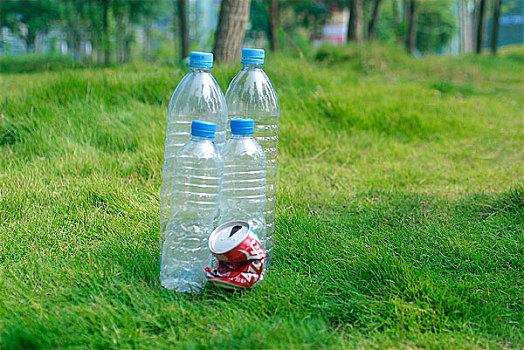 放置草地上的塑料瓶和易拉罐