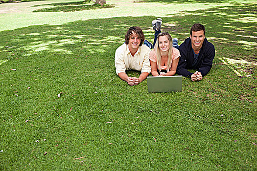 三个,微笑,学生,看镜头,公园,卧,笔记本电脑
