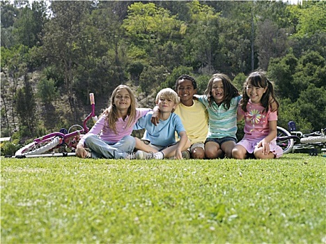 一群孩子,7-9岁,坐,草,公园,自行车,微笑,头像,贴地拍摄