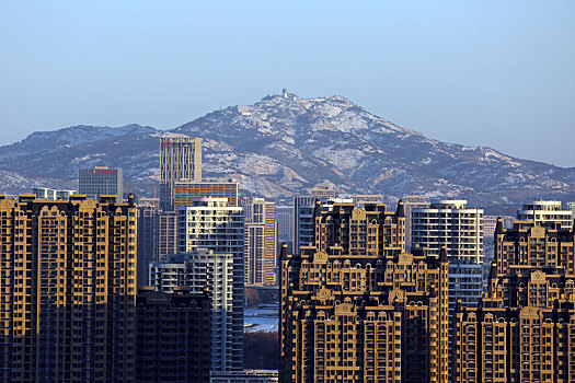 山东省日照市,雪后初晴的港城空气清新,高楼大厦与皑皑雪山相映成趣