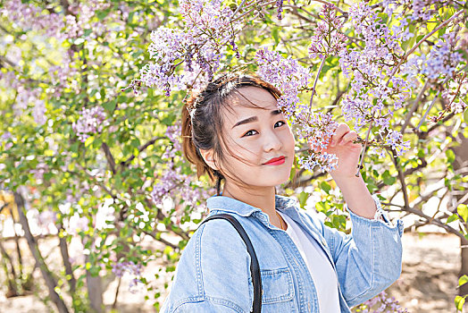 年轻漂亮的女孩在公园里欣赏春季美景