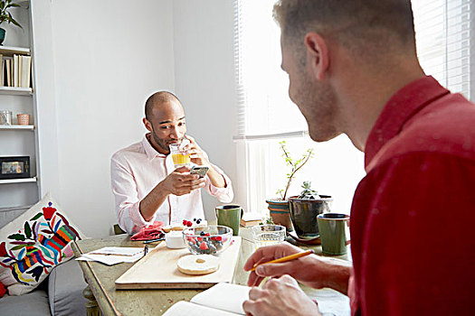 男人,坐,餐桌,喝,橙汁,看,智能手机