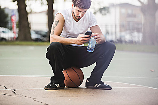 男青年,篮球,坐,球,发短信,智能手机