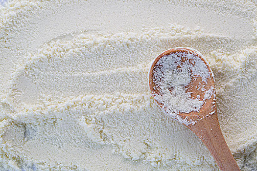 奶粉的纹理背景和一个木勺