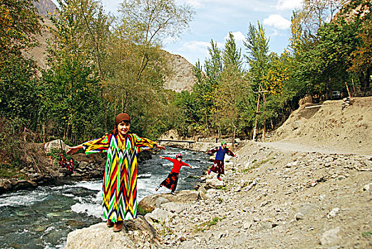 tajikistan,penjakent,portrait,of,local,girl,in,traditional,dress,playing,by,the,river