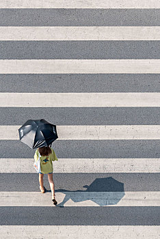 人行道上过路的打伞美女