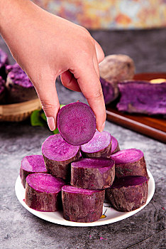 手拿一块切开的紫薯