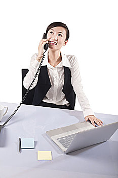 正在办公室用打电话的商务女性