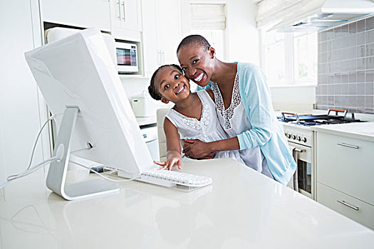 高兴,微笑,母亲,女儿,用电脑,厨房