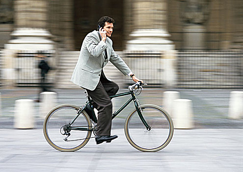 男人,穿,套装,拿着,手机,耳,骑,自行车