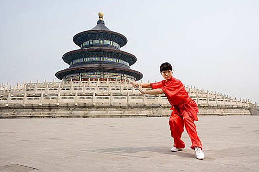 中国武术--一名女武术运动员在天坛祈年殿前练刀法