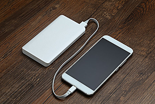 充电宝和智能手机放在木桌上
