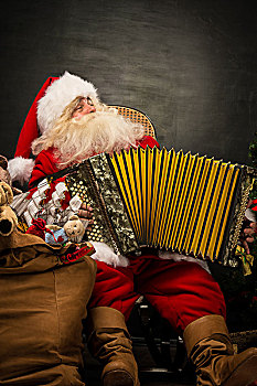 圣诞老人,坐,扶手椅,靠近,圣诞树,在家,演奏音乐,手风琴