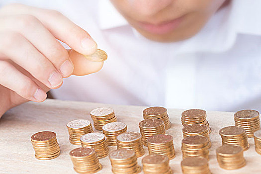 男人手拿金幣疊起來，寓意投資、理財、積蓄、財富管理等概念