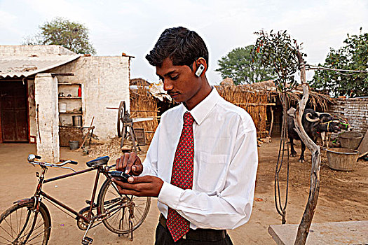 印度,北方邦,男青年,穿,衬衫,领带,智能手机,蓝牙耳机,户外,乡村,家