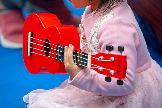 一群小孩在室外公園,學習彈吉他,玩著乌克丽丽