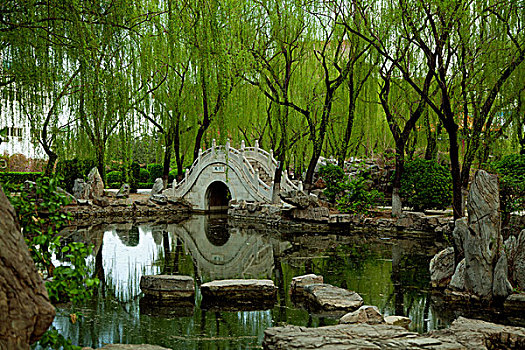 中国古典园林湖泊中的石板路和拱形桥