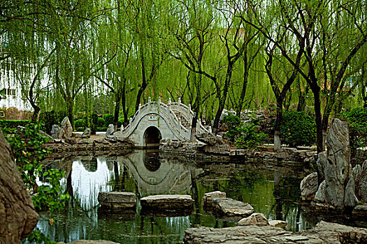 中國古典園林湖泊中的石板路和拱形橋