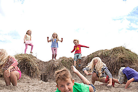 一群孩子,跳跃,沙丘,威尔士,英国