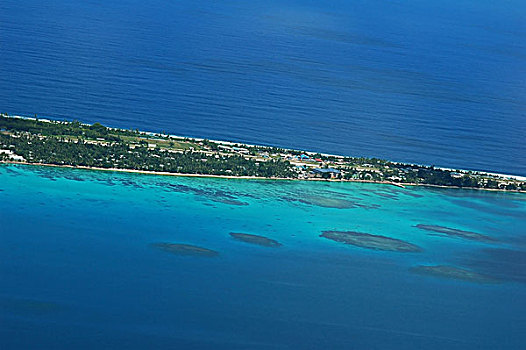 tuvalu,funafuti,aerial,view,of,shoreline,along,the,landscape,with,trees,and,houses,boat,anchored,by,jetty