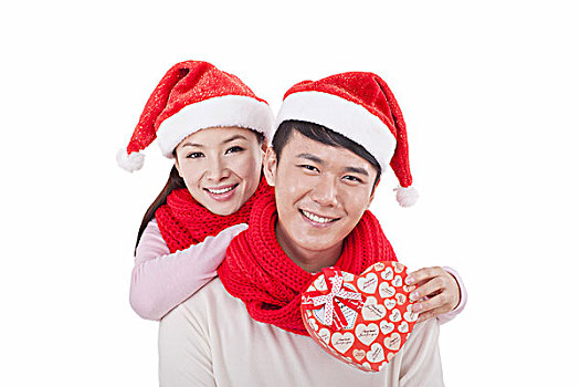 戴着圣诞帽的青年伴侣拿着礼物