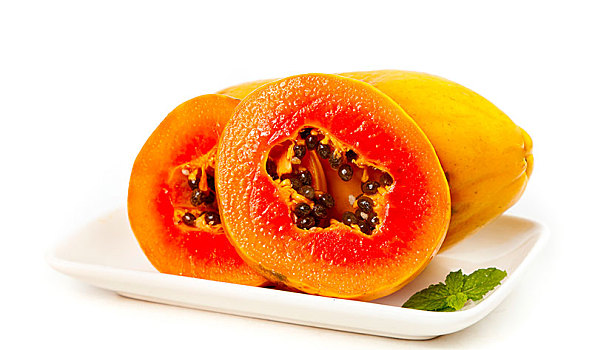 白底上放着一盘切开的红心牛奶木瓜