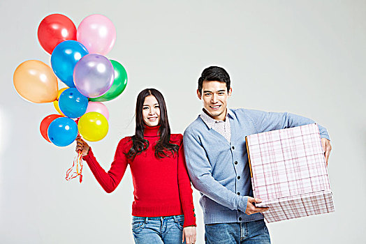 拿气球和情人节礼物的亚洲情侣