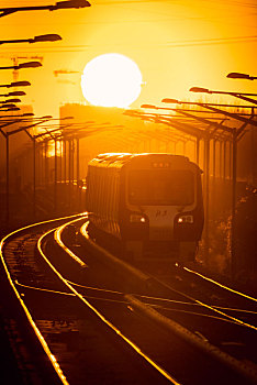 北京冬季清晨地铁13号线在太阳照射下进站