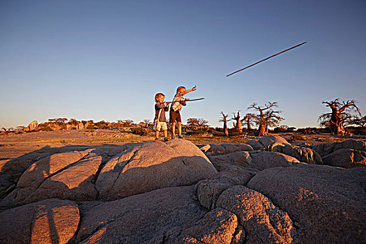 两个男孩,站立,石头,投掷,矛,马卡迪卡迪盐沼,博茨瓦纳