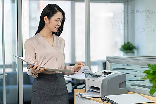 年轻商务女士使用打印机