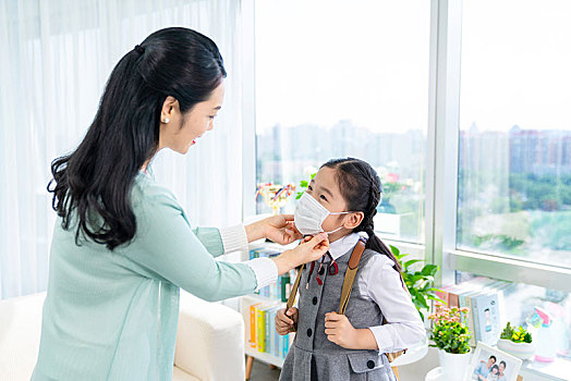 媽媽給女兒戴口罩