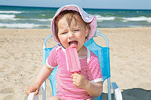 女性,幼儿,戴着,太阳帽,吃,冰棍,海滩,椅子